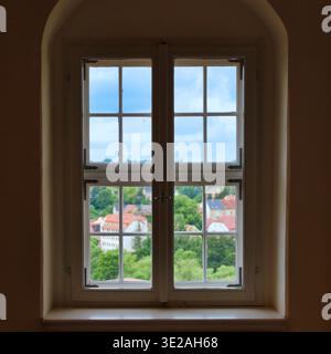 Vista attraverso una classica finestra a reticolo del Castello di Colditz che si affaccia sulla città sassone, pittoresco panorama sui tetti rossi Foto Stock