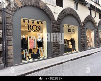 Rosi, via del corso. Firenze, Italia. Vista sulla strada di una lussuosa boutique italiana con manichini che espongono abiti e calzature moderni in pietra ad arco Foto Stock