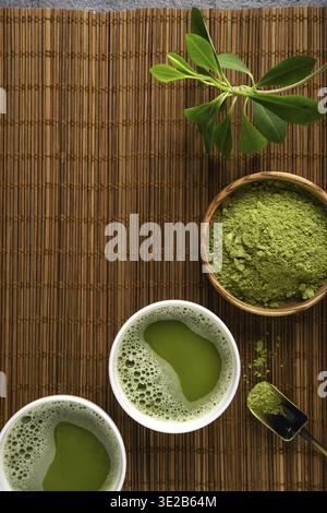Polvere di tè Matcha e accessori per il tè su sfondo di tovagliolo di bambù. Cerimonia del tè. Bevanda salutare. Bevanda tradizionale giapponese Foto Stock