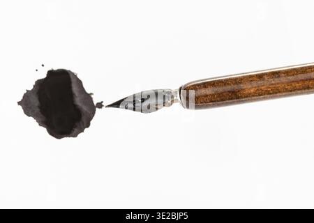 Vista dall'alto del pennino verniciato nero del portapenne marrone e inchiostro nero su carta bianca Foto Stock