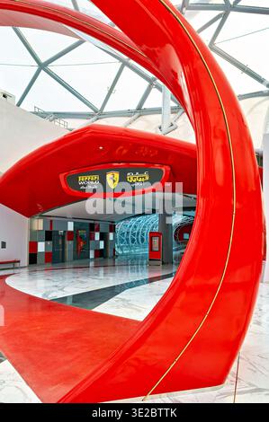 Le persone camminano attraverso l'area d'ingresso del parco a tema Ferrari World ad Abu Dhabi, godendosi le attrazioni e l'atmosfera al suo interno. Foto Stock