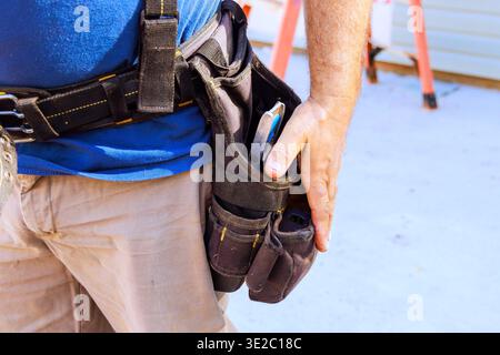 Il lavoratore si trova in cantiere, mentre gli strumenti pronti all'uso sono in corso. Foto Stock