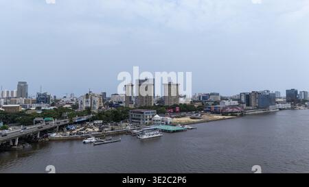 Lagos, Nigeria - 2 agosto 2025: Veduta aerea di Lagos rivela una miscela di alti e moderni edifici lungo il lungomare, contrastati da un fiume sereno Foto Stock