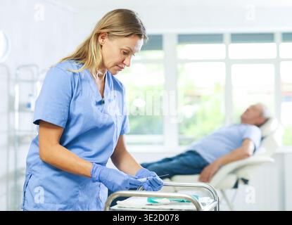 Iniettore di riempimento per infermiere di mezza età nell'armadio medico Foto Stock
