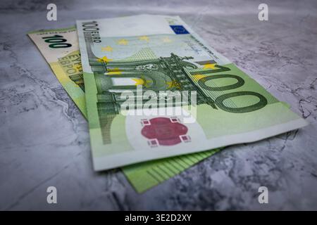 Primo piano di banconote in euro su una superficie in marmo che mostra banconote da 100 e 10 euro. Concetto di risparmio in contanti finanza personale cambio valuta ed europeo Foto Stock