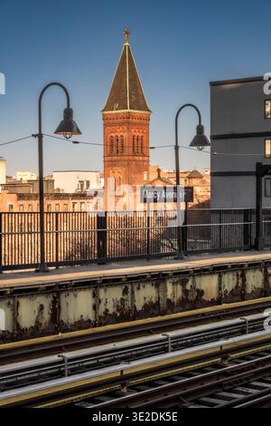 Brooklyn, NY - US - 14 marzo 2026 la luce dorata del tramonto illumina la storica torre della chiesa luterana di St. Paul accanto alla piattaforma di Marcy Ave a Brooklyn Foto Stock