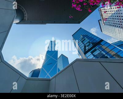 18 marzo 2026 - Hong Kong: Una suggestiva vista ad angolo basso che mostra un moderno quartiere degli affari di Hong Kong con edifici contemporanei e vivaci commerci Foto Stock