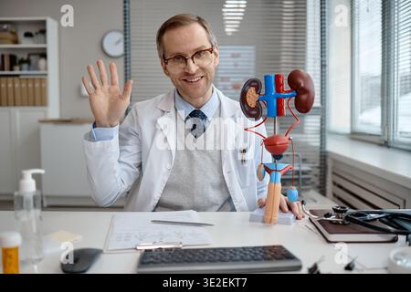 Ritratto dell'uomo caucasico di mezza età urologo che sventola durante la consultazione Foto Stock