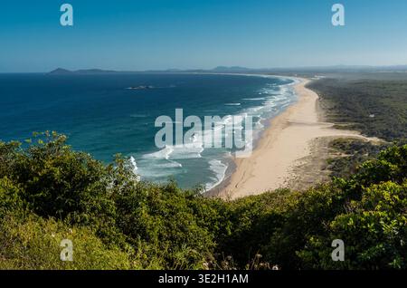 Spettacolare scenario costiero nel nuovo Galles del Sud con una lunga spiaggia di sabbia, mare blu e lussureggiante vegetazione verde Foto Stock