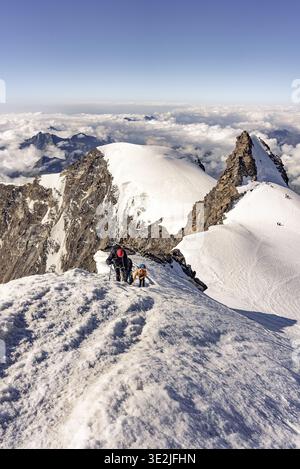 Scalatori su una stretta cresta di neve esposta Foto Stock