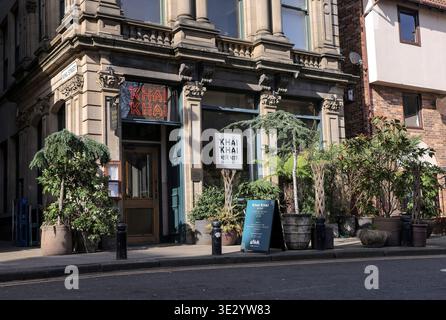 Il ristorante indiano Khai Khai si trova in Queen Street, Newcastle Quayside. Il ristorante presenta un'accogliente entrata con piante e cartelli che attirano i visitatori. L'area e' conosciuta per la sua atmosfera vivace ed e' un posto preferito per mangiare e socializzare. I visitatori possono ammirare i vari luoghi di interesse locali nelle vicinanze mentre esplorano questa vivace zona di Newcastle. Il ristorante offre cucina indiana tradizionale e un vivace ambiente da pranzo, rendendolo una scelta popolare sia per la gente del posto che per i turisti. Foto Stock
