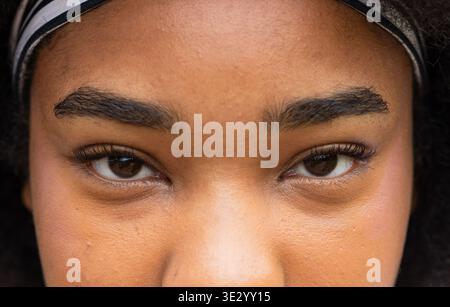 Donna afroamericana che guarda da vicino occhi, sopracciglia, ciglia lunghe, fascia in tessuto Foto Stock