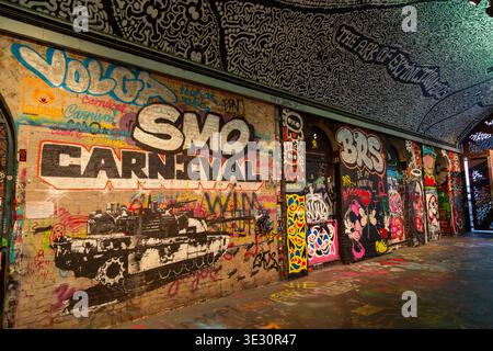 Opere d'arte di graffiti in Leake Street Graffiti Tunnel, un famoso spazio d'arte urbana situato sotto la stazione di Waterloo a Londra Foto Stock