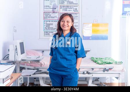 Ritratto di un medico amichevole con stetoscopio, accanto a uno scanner diagnostico a ultrasuoni in una clinica. Tecnologia e assistenza sanitaria Foto Stock
