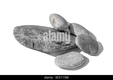 Vista prospettica di rocce grigie lisce impilate isolate su sfondo bianco. L'illuminazione professionale da studio mette in risalto le vene minerali dettagliate Foto Stock