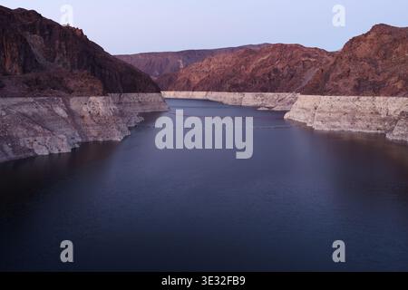 Vista panoramica a monte della diga di Hoover di fronte al lago Mead, con acqua artificiale, montagne circostanti e segni visibili del livello dell'acqua. Foto Stock