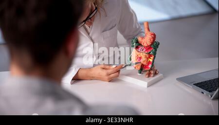 Il medico discute i polipi del colon in dettaglio con la paziente femminile interessata durante la consultazione medica Foto Stock