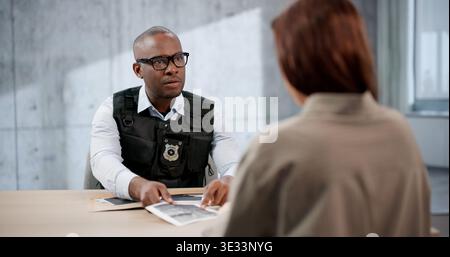 Detective serio e procuratore interrogare Un giovane sospettato in ufficio. L'investigatore interroga Un criminale Foto Stock