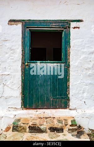 Vista ravvicinata della porta verde dell'edificio coloniale storico Foto Stock