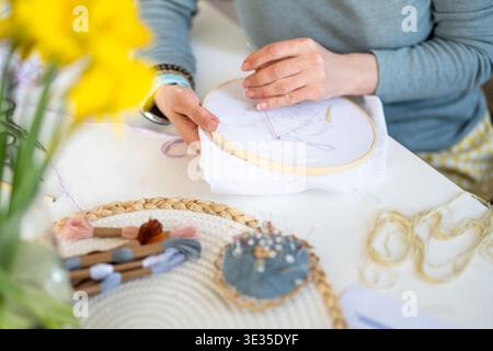 Ricamo ragazza su tessuto allungato in Un cerchio, Un'attività creativa, con Un primo piano di mani Foto Stock