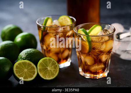 Bicchieri di gustoso cocktail Cuba Libre su sfondo di legno scuro, attenzione selettiva. Cuba Libre o cocktail di tè freddo Long Island. Foto Stock