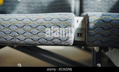 Porte di ricarica USB tra i sedili passeggeri in un comodo e moderno autobus Foto Stock