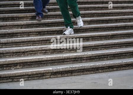 Scalinata di Trinità dei Monti a Roma, Italia. Primo piano di piedi camminando lungo l'antica pietra di travertino intemprata. Foto Stock