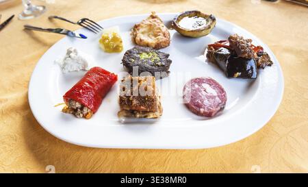 Viaggia in Italia, cucina italiana - vari spuntini e antipasti siciliani locali su piatto bianco in Sicilia Foto Stock
