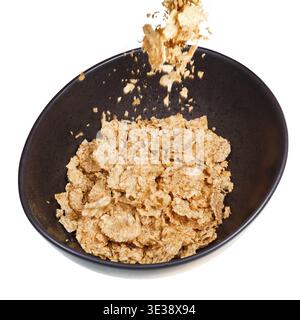 Cereali spolverati in una ciotola scura isolata su sfondo bianco Foto Stock