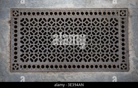 Griglia da pavimento in ghisa in stile vittoriano, spesso utilizzata per la ventilazione o come copertura per sistemi di riscaldamento a pavimento. Foto Stock
