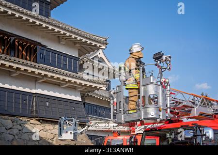 Servizio antincendio che conduce un'esercitazione antincendio al castello di Matsumoto in Giappone, proteggendo l'edificio storico di rilevanza nazionale Foto Stock