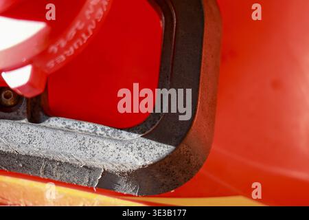 Primo piano del rivestimento e del guscio rosso dell'elmetto di sicurezza. la bretella di fissaggio protettiva garantisce la massima sicurezza grazie all'imbottitura in espanso e al design con elmetto per applicazioni industriali Foto Stock