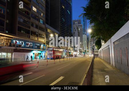 Leighton Road durante una tranquilla domenica sera con traffico leggero, strade illuminate della città e alti edifici sotto un profondo cielo blu crepuscolo. Foto Stock