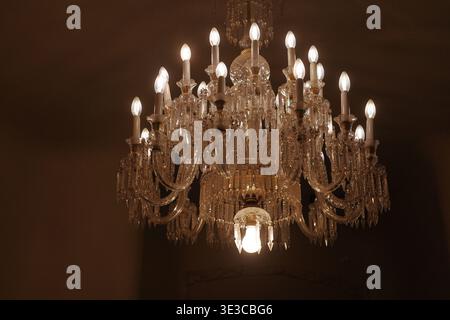 Lampadario di cristallo decorato illuminato all'interno di Casa Milà (la Pedrera), il punto di riferimento modernista di Antoni Gaudí e sito patrimonio dell'umanità dell'UNESCO, Barcellona, Spagna. Foto Stock