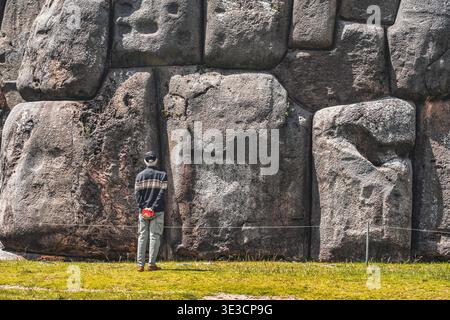 Cusco, Perù - 22 marzo 2025: Turista che guarda le imponenti mura megalitiche di pietra di Sacsayhuaman a Cusco, Perù Foto Stock