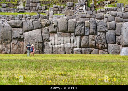 Cusco, Perù - 22 marzo 2025: Turisti che guardano le imponenti mura megalitiche di pietra di Sacsayhuaman a Cusco, Perù Foto Stock