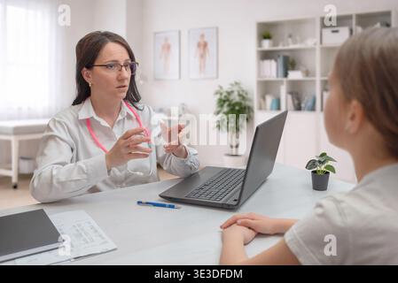 medico consulente paziente con laptop in clinica che rappresenta l'assistenza sanitaria digitale, consulenza medica e consulenza professionale Foto Stock