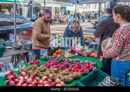Vivace stazione di frutta e verdura fresca presso Bridport Charter Street Market, Dorset, Inghilterra - acquirenti che acquistano frutta e verdura. Dorset. Foto Stock