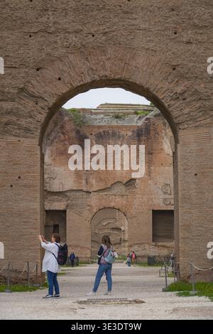 Terme di Caracalla, Terme di Caracalla. Roma, Italia. Le enormi rovine imperiali del III secolo incorniciano i turisti a fotografare gli antichi mattoni. Foto Stock