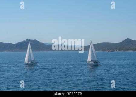 Barche a vela bianche che navigano su un mare blu calmo. Sfondo marino estivo per viaggi, tempo libero e concetti di vela Foto Stock