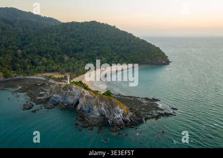 Parco nazionale MU Ko Lanta, Krabi, Thailandia – 27 febbraio 2020: Vista aerea di un faro su un promontorio roccioso accanto a una spiaggia curva. Foto Stock