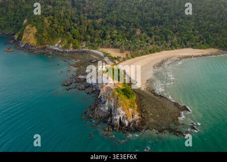 MU Ko Lanta National Park, Krabi, Thailandia – 27 febbraio 2020: Vista aerea di un faro su un promontorio roccioso con distese di barriera corallina. Foto Stock