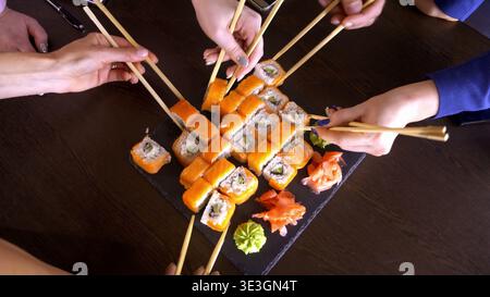 Cena in comune con sushi roll e guarnigioni Foto Stock