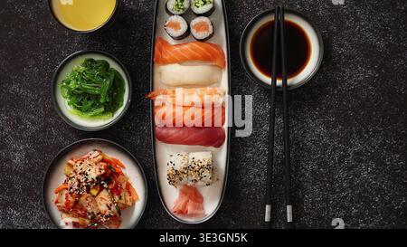 Piatto di sushi assortito con nigiri e maki su una superficie scura Foto Stock