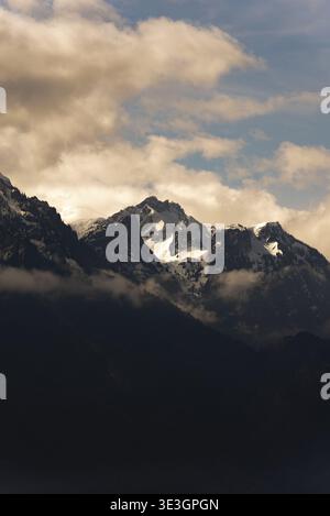 Nuvole spettacolari parzialmente oscure vette baciate dal sole nelle Alpi francesi Foto Stock