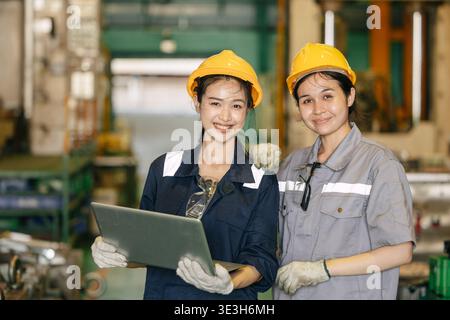Ritrattista donne lavoratrici team amico lavorare in fabbrica industria pesante felice sorriso insieme Foto Stock