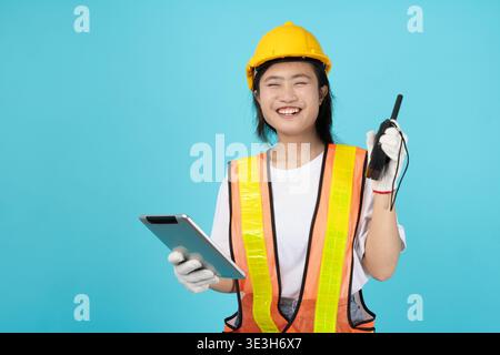 Ritratto felice sorridente ingegnere donna asiatica giovane adolescente che indossa giubbotto riflettente di sicurezza modello isolato studio in servizio radio operare Foto Stock
