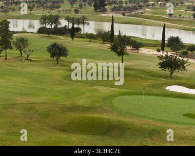 Grande stagno che confina con un campo da golf, fairway e green Foto Stock