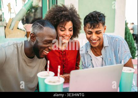 Un gruppo di amici universitari multiculturali ama fare shopping online e divertirsi insieme Foto Stock
