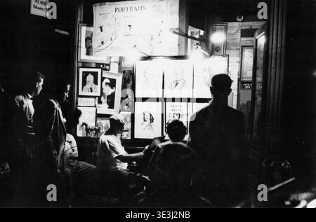 Questa accattivante fotografia di strada, probabilmente catturata da Angelo Rizzuto negli anni '1940, raffigura un vivace stand di ritrattisti di notte nel Greenwich Village di New York. Le persone si riuniscono intorno all'artista, illuminati dalle luminose lampade da esposizione, che mostrano ritratti in bianco e nero da 2,00 dollari. Foto Stock